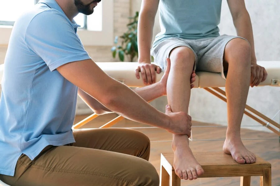 A doctor examining a man's leg at a Podiatry Practice.