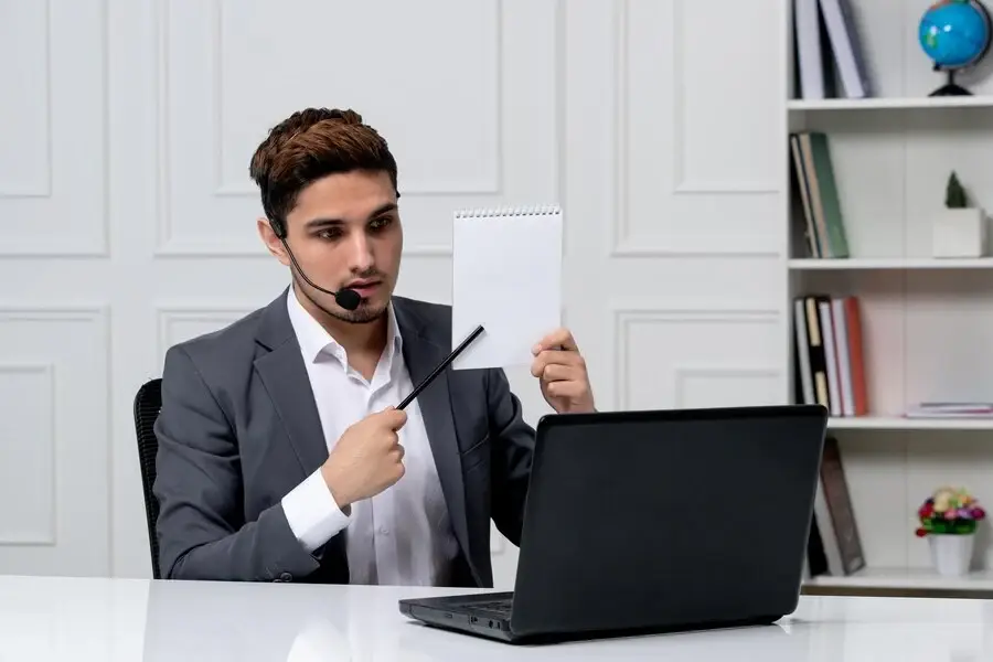 Professional man in suit working at desk with laptop and paper, focusing on archiving clean claims.